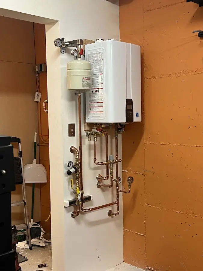 Plumbing technician inspecting water heater connections in Westlake